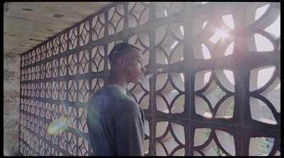 a man standing in front of a metal screen