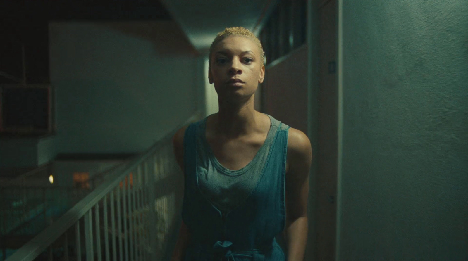 a woman standing in a hallway next to a railing