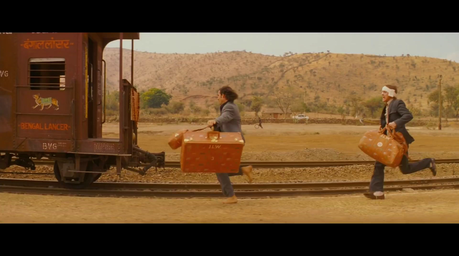 a couple of people walking across a train track