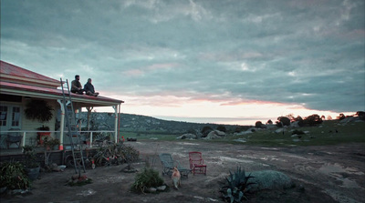 a couple of people sitting on the roof of a house