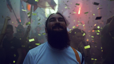 a man with a beard and a beard standing in front of confetti