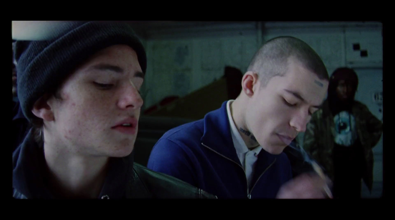 two young men are looking at a cell phone