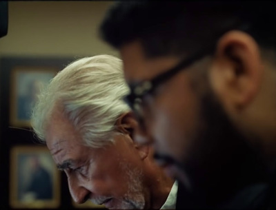 two men looking at something in a mirror