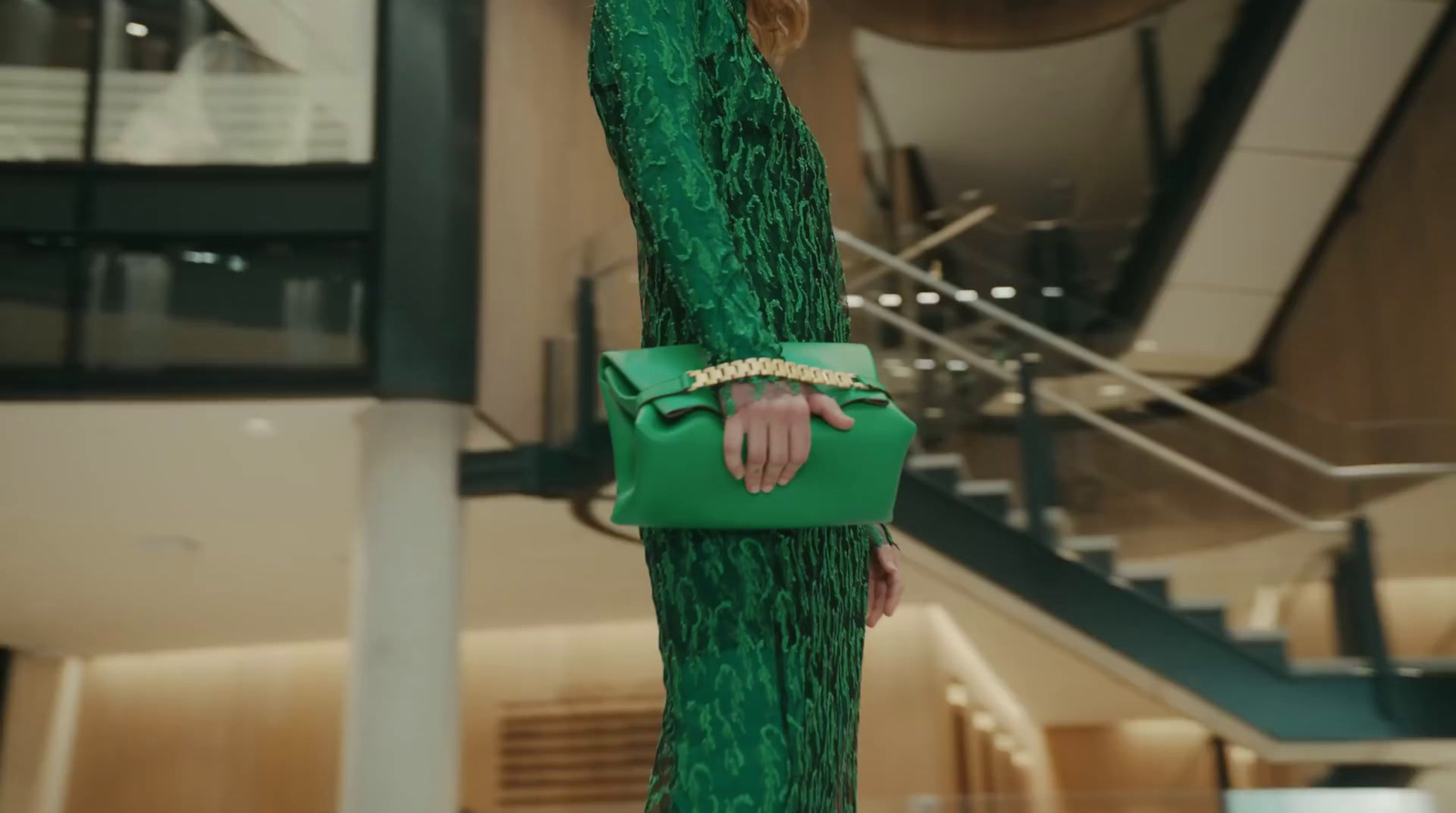 a woman in a green dress holding a green purse