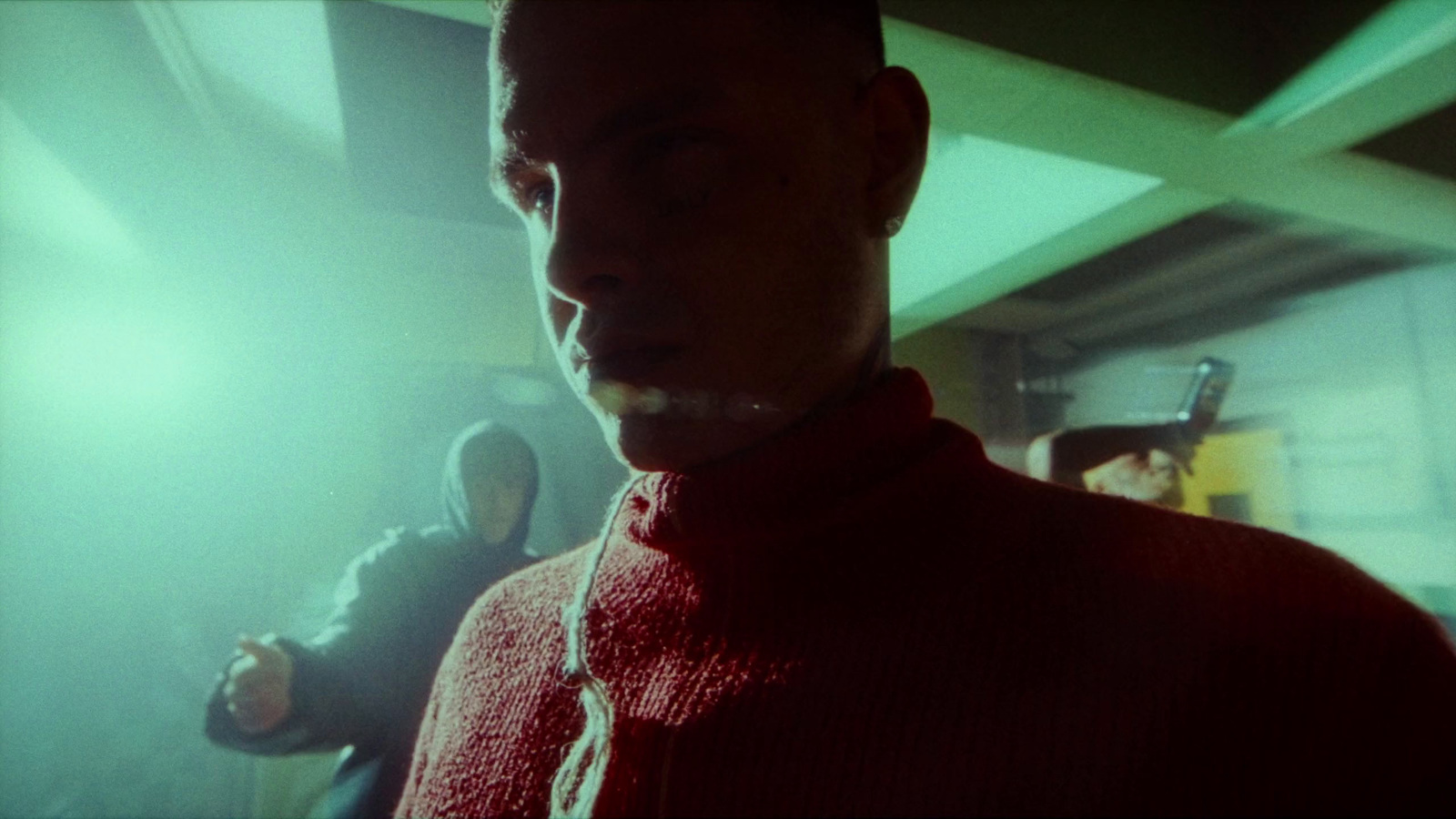 a man in a red sweater standing in a room