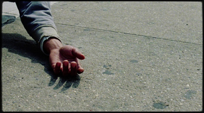 a person's hand reaching for something on the ground