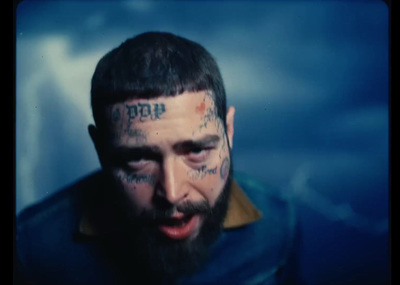 a man with tattoos on his face looking at the camera