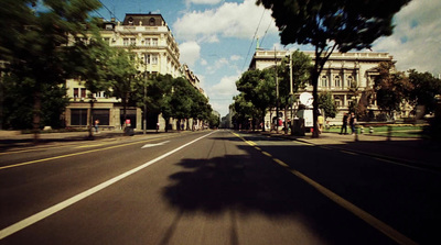 a car driving down a street next to tall buildings