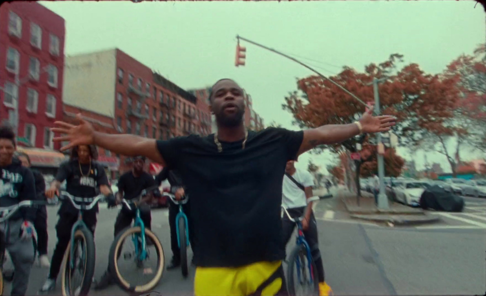 a man standing in the middle of a street with his arms outstretched