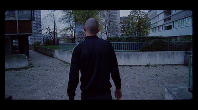 a man walking down a sidewalk in a city