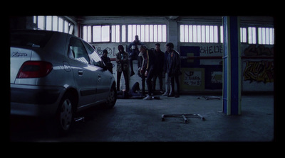 a group of young men standing next to a parked car