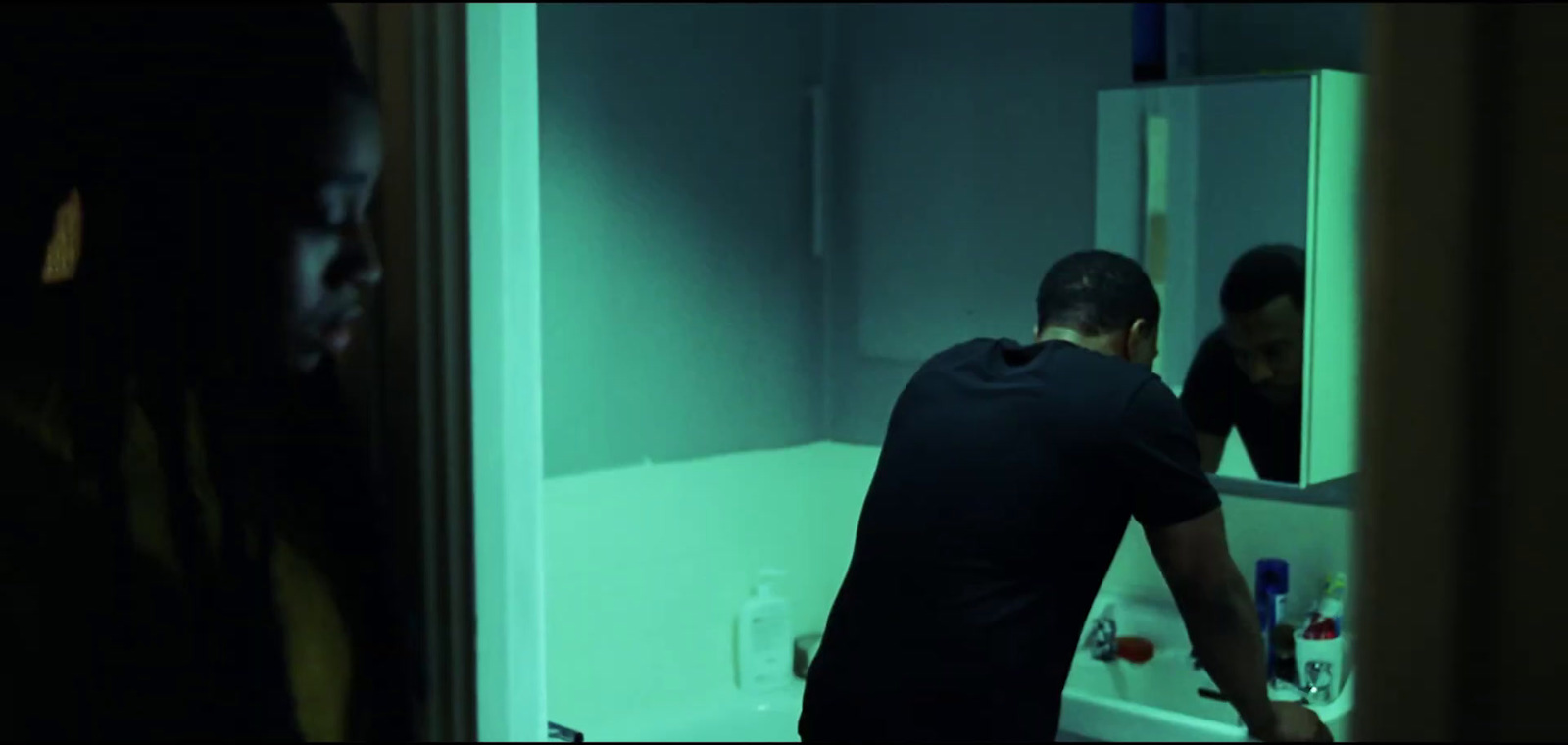 a man standing in front of a bathroom mirror