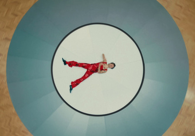 a man in a red suit laying on top of a white circle