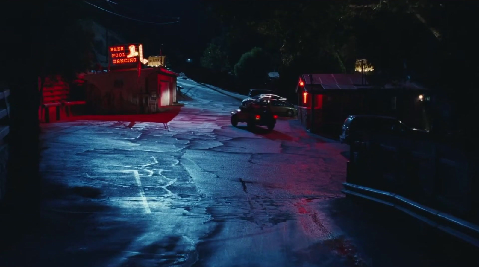 a car driving down a street at night