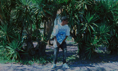 a man standing in front of a bunch of palm trees