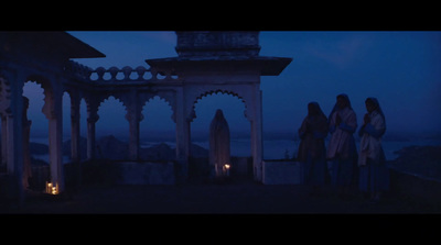 a group of people standing around a gazebo at night