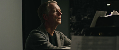 a man sitting at a table with a book in front of him