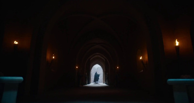 a person standing in a dark tunnel with a light at the end