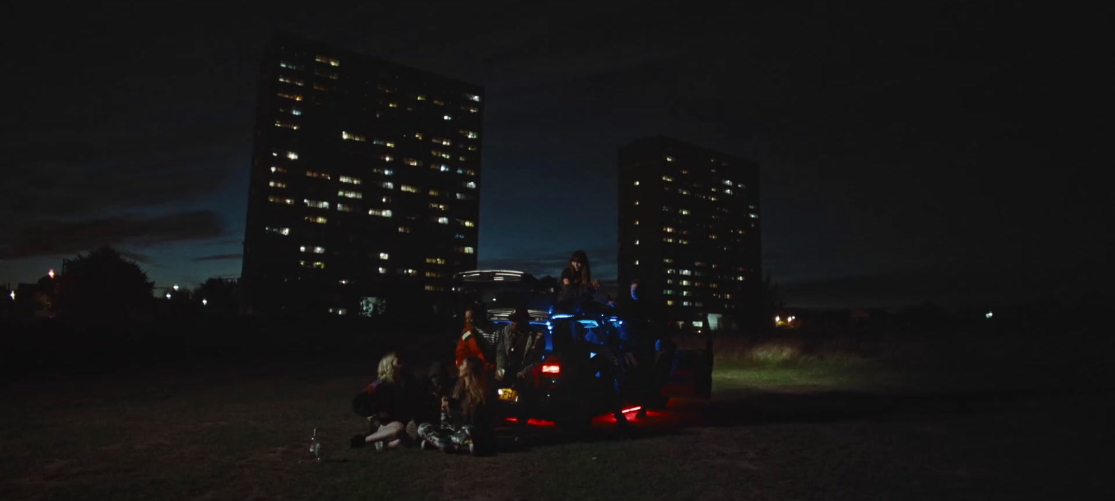 a group of people standing in the back of a truck at night