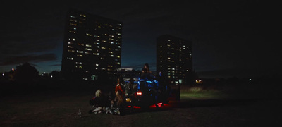 a group of people standing in the back of a truck at night