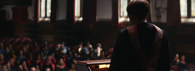 a man standing at a podium in front of a crowd of people