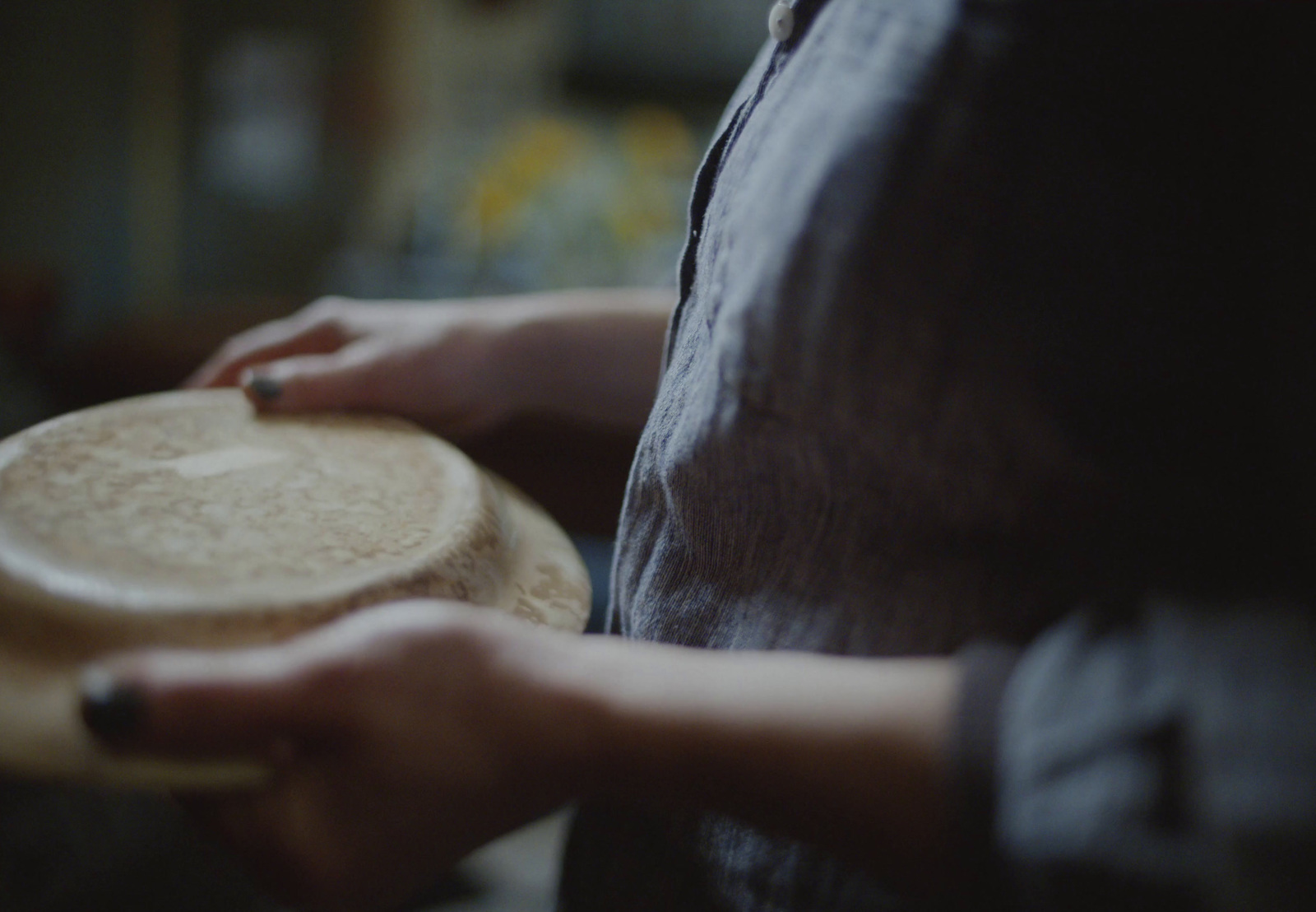 a close up of a person holding a wooden plate