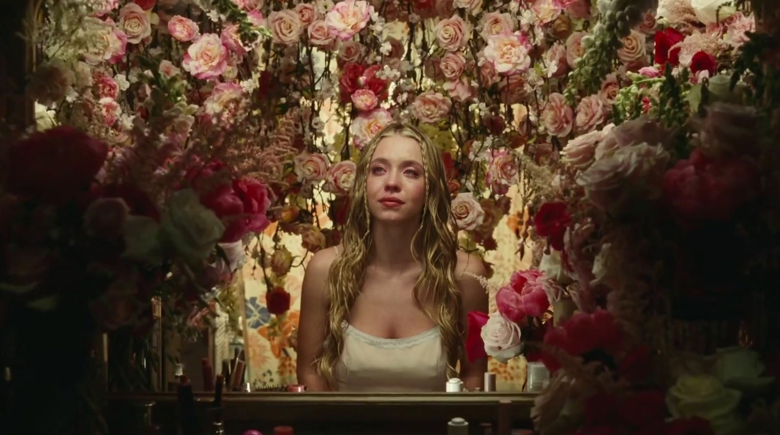 a woman standing in front of a bunch of flowers