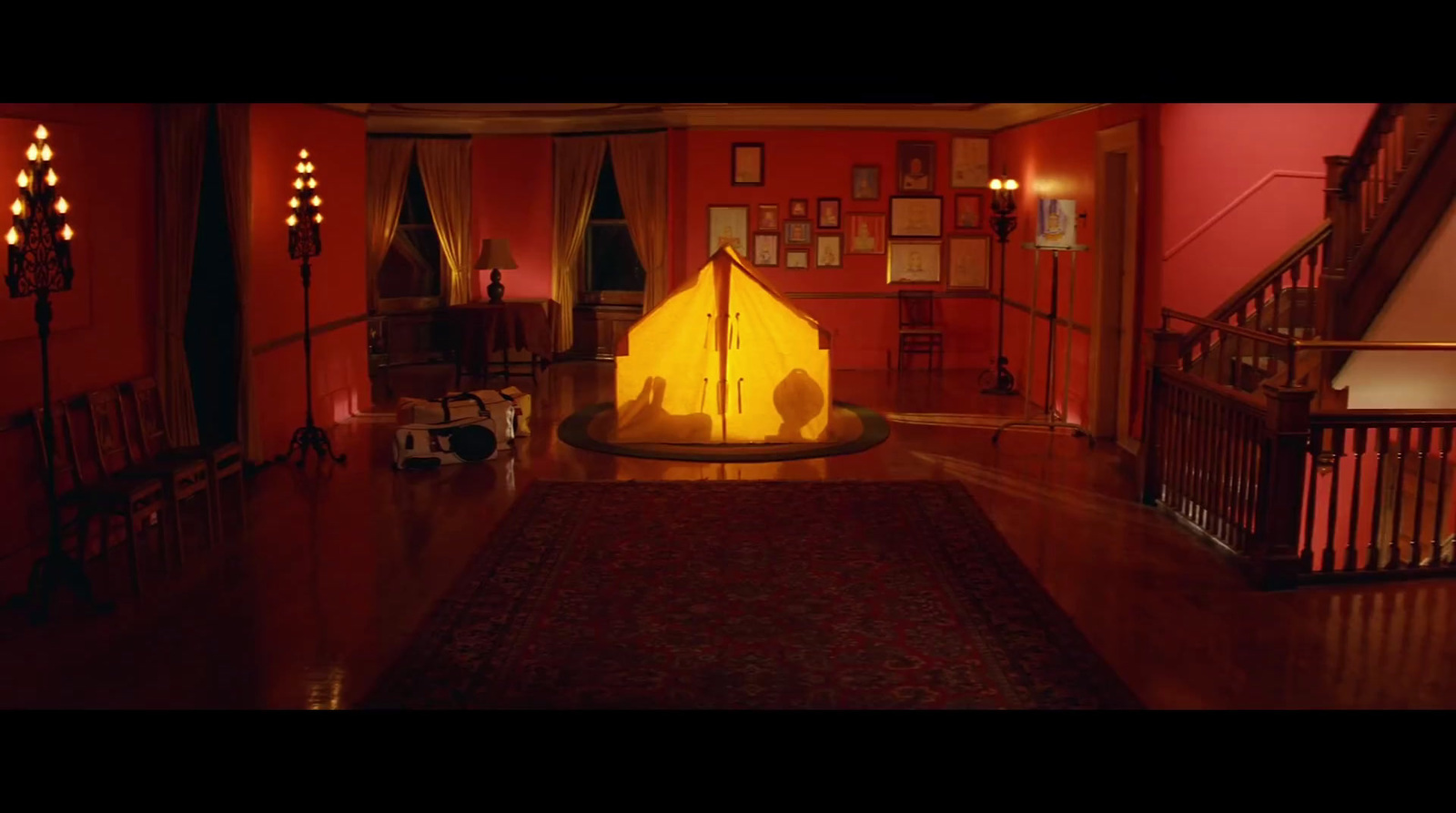 a living room with red walls and wooden floors