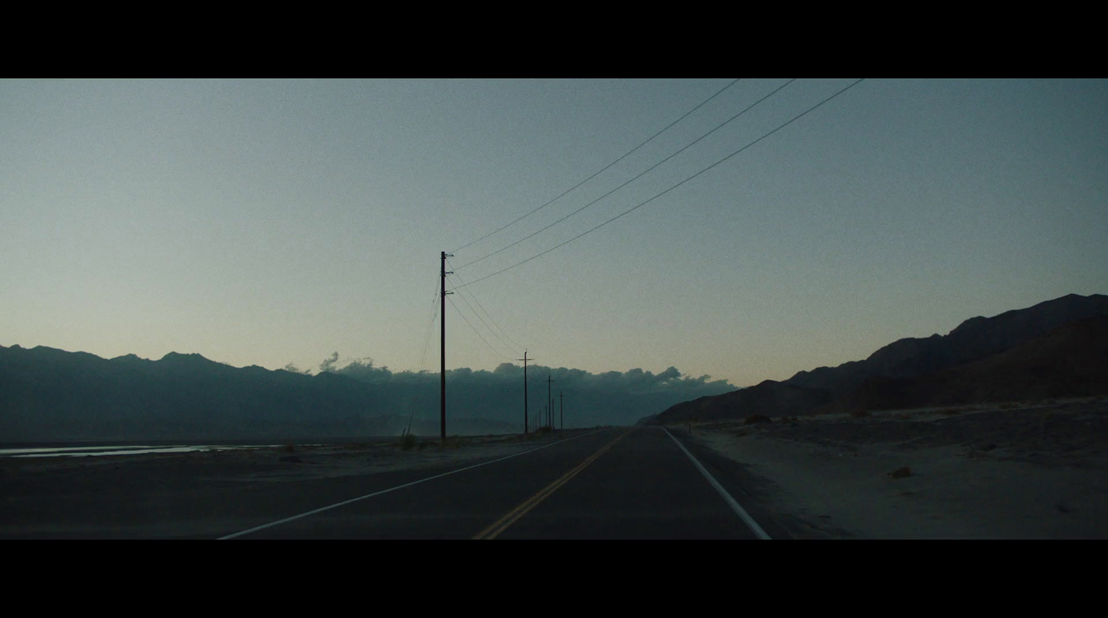 an empty road with mountains in the background