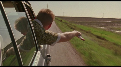 a man holding a remote control out of a car window