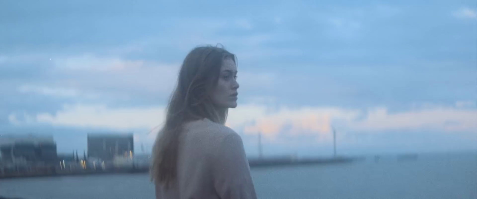 a woman standing in front of a body of water