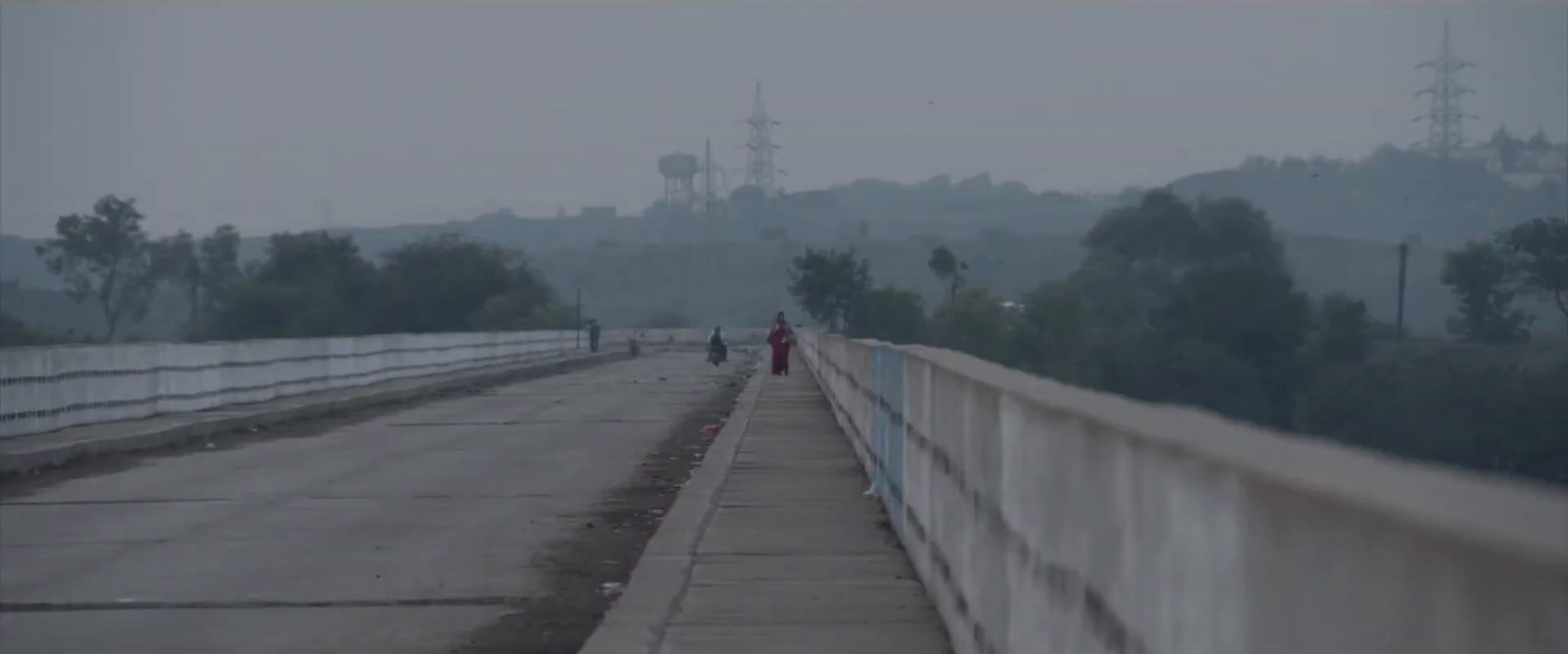 a couple of people walking across a bridge