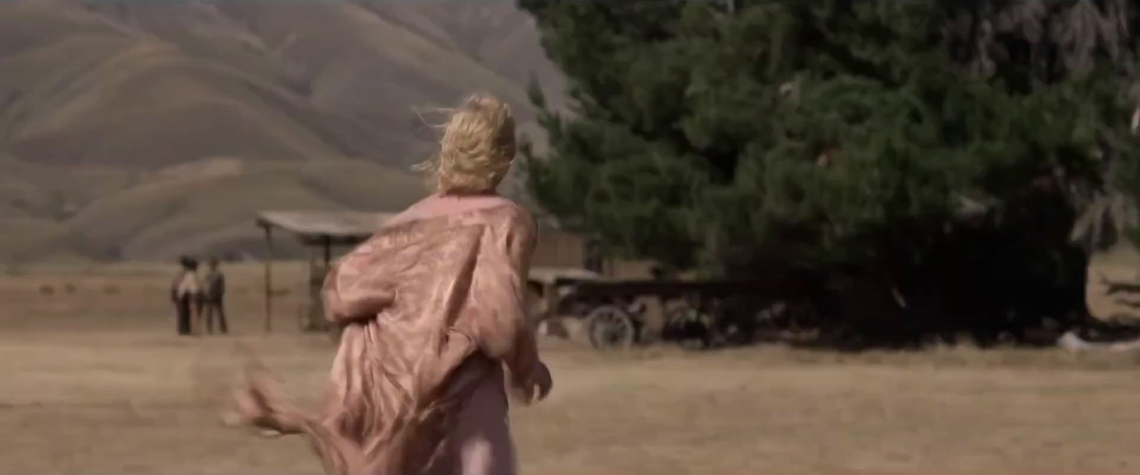 a woman in a pink dress is playing frisbee