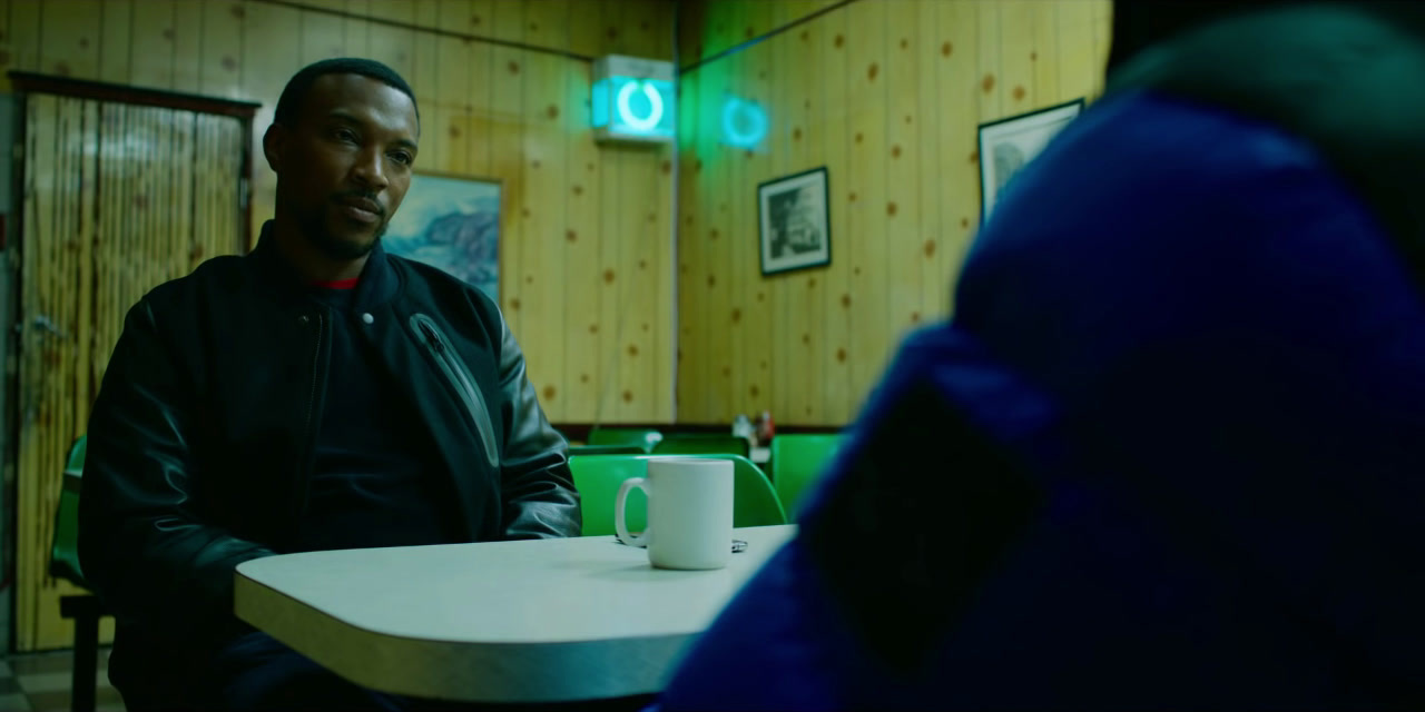 a man sitting at a table with a cup of coffee