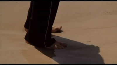 a person standing on a beach with their feet in the sand