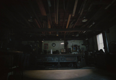 a dark room with a table and a clock on the wall