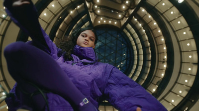 a woman in a purple jacket laying on the ground