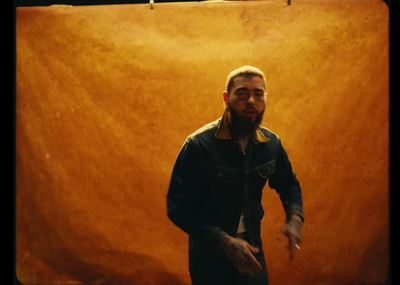 a man standing in front of a brown wall