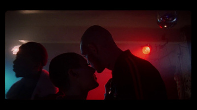 a man and a woman kissing in a dark room