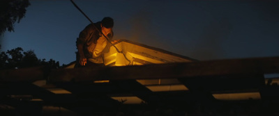 a man standing on top of a roof next to a fire