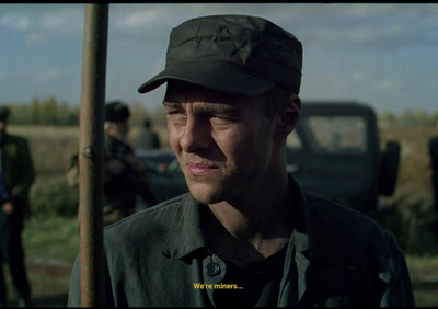 a man wearing a hat standing in front of a truck