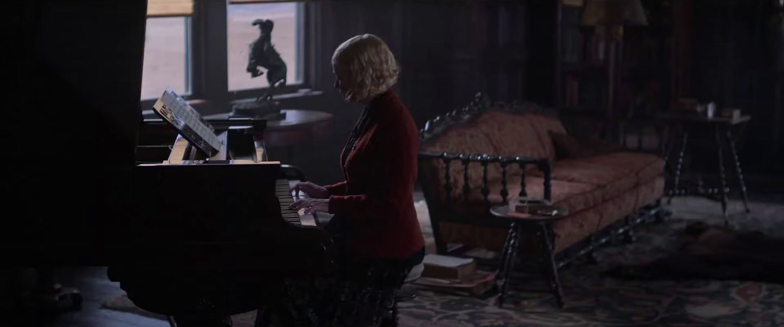 a woman playing a piano in a dark room