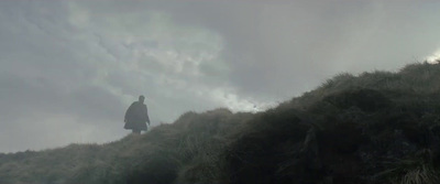 a man standing on top of a lush green hillside