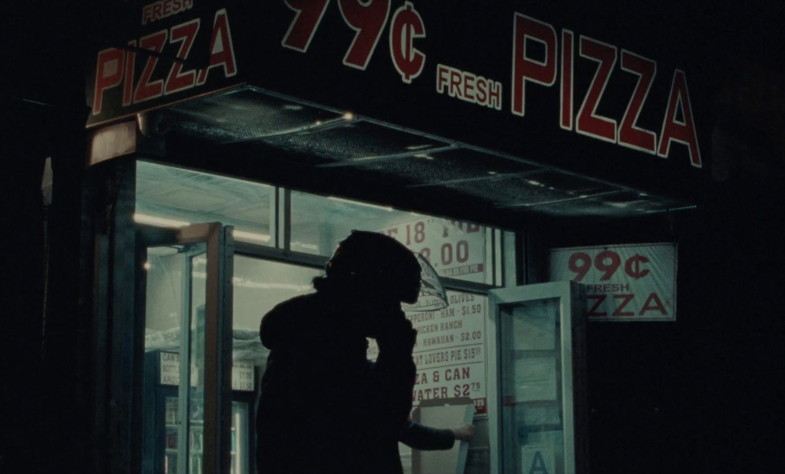 a person standing in front of a pizza restaurant