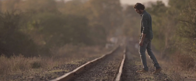 a man standing on a train track next to a forest