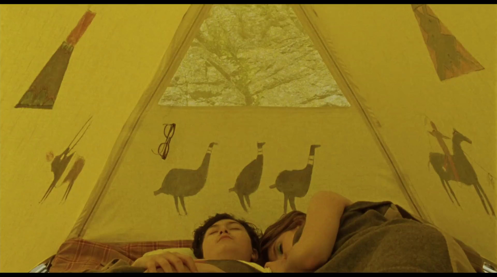 a man and a woman laying in a tent