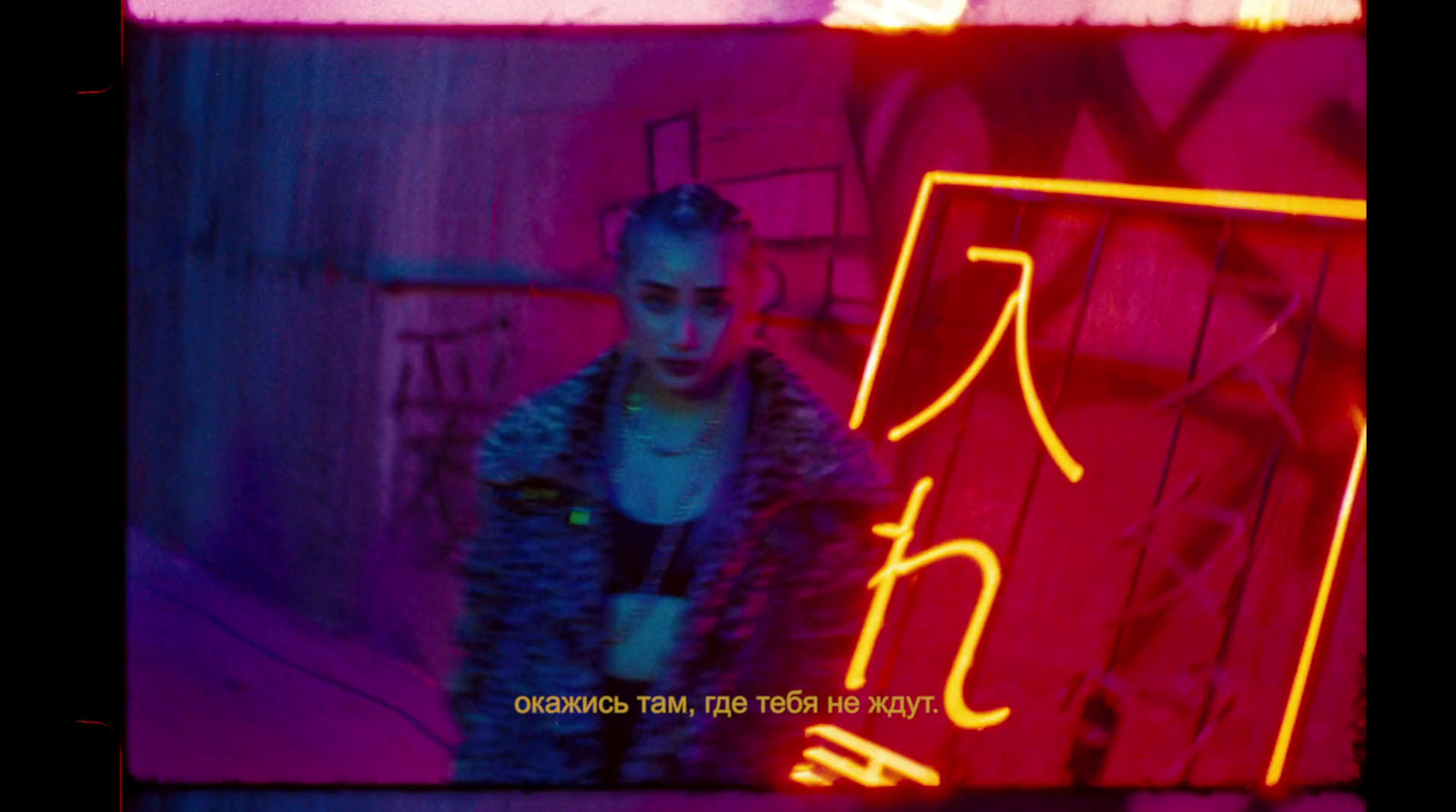 a woman standing in front of a neon sign