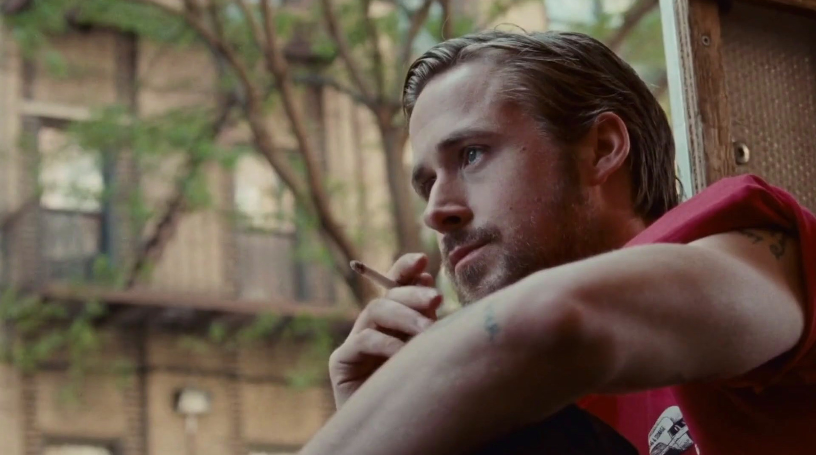 a man smoking a cigarette in front of a building