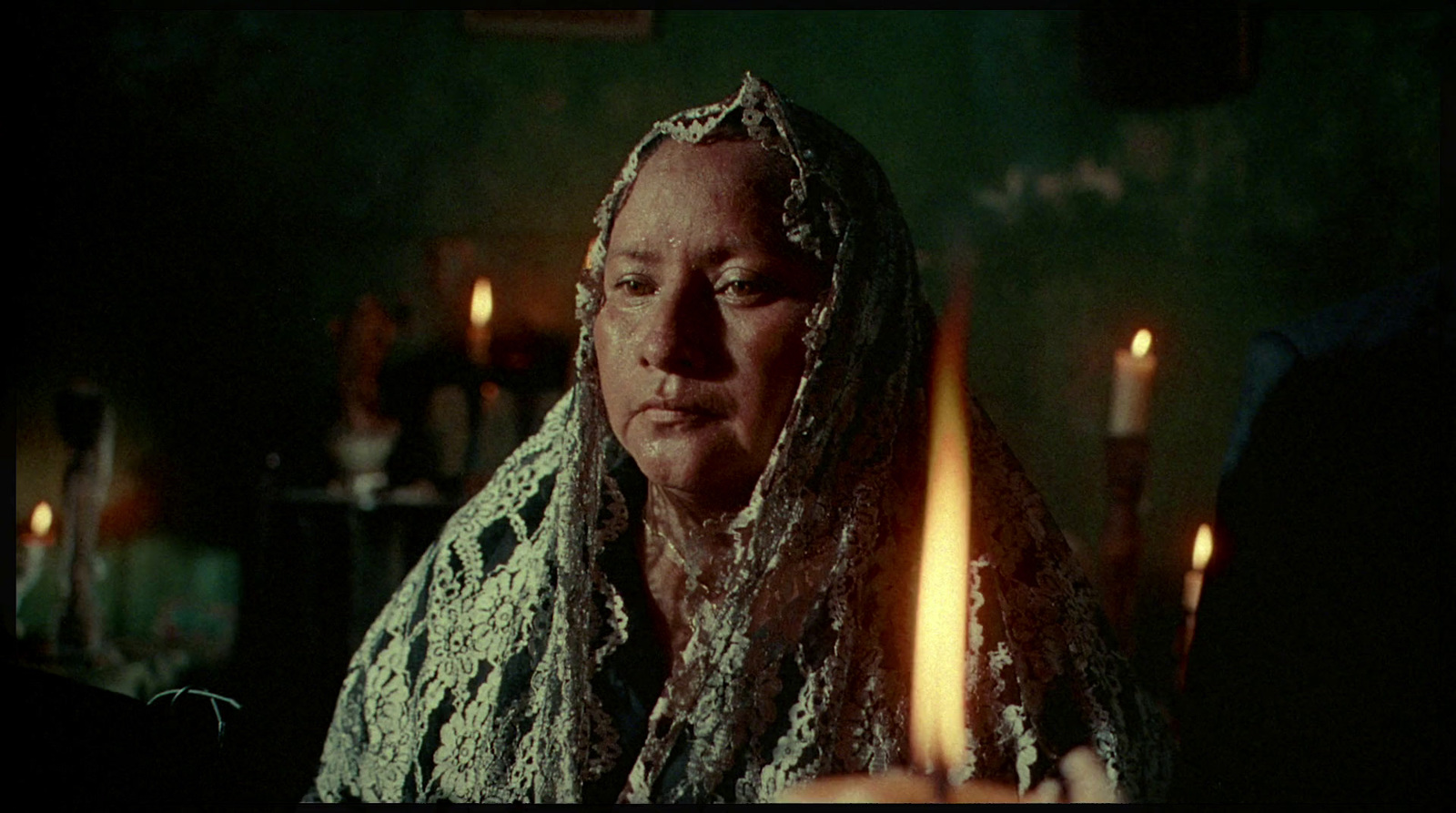 a woman with a veil on her head and candles in front of her