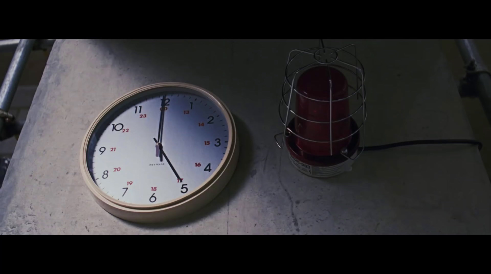 a clock sitting on the ground next to a cage